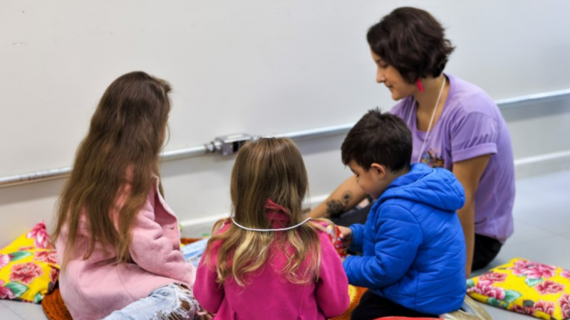 Imagem de crianças brincando com educadora